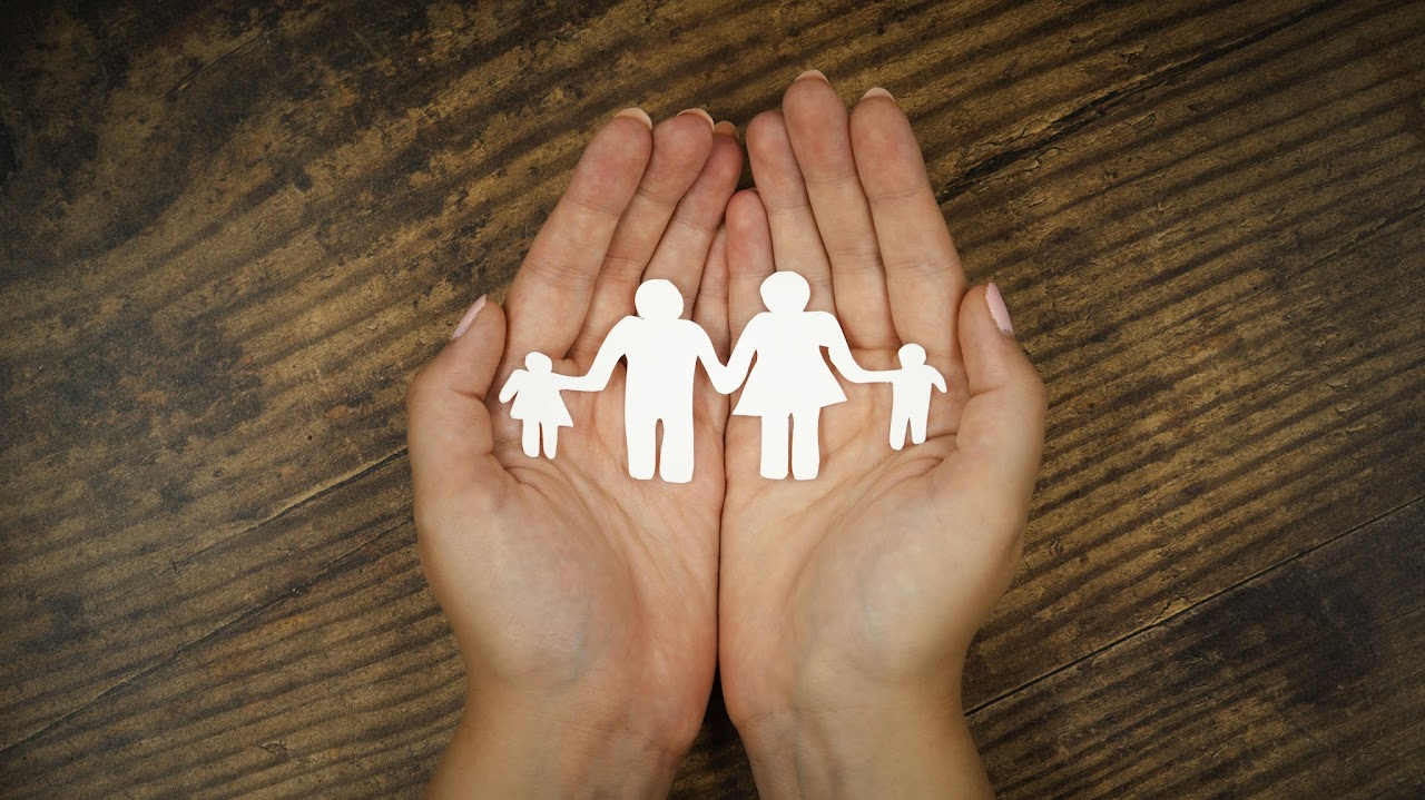 Hands protecting a paper family