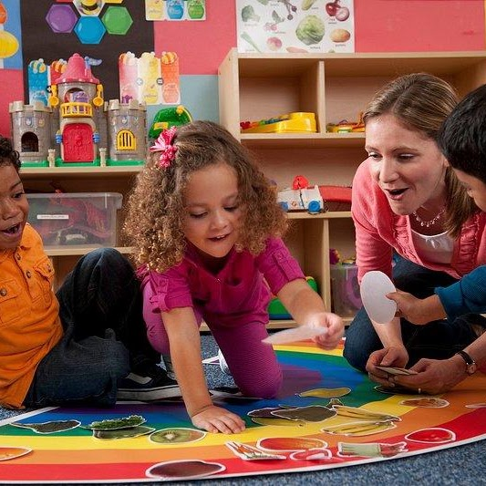 Teacher supporting children in an early learning classroom